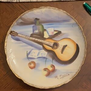 It’s a decorative plate painted by M. Kuritz